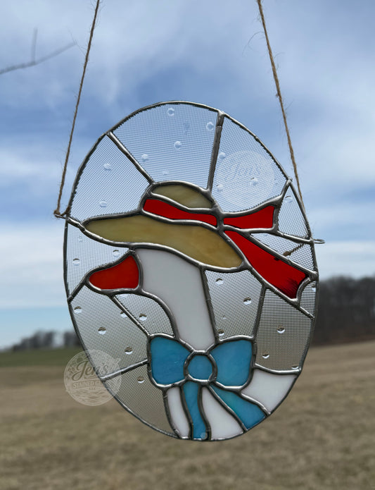 Stained glass panel with a design of a person wearing a hat